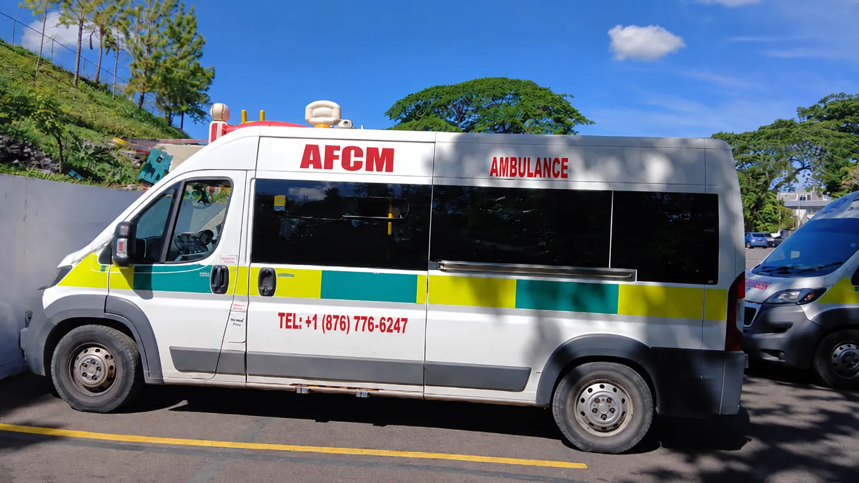 AFCM ambulance parked in Jamaica, with the AFCM name and telephone number on its side